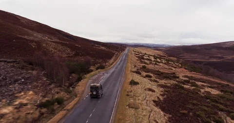 Car travelling along bumpy mountain main road, Scotland drone aerial 4K Stock Footage 104586250