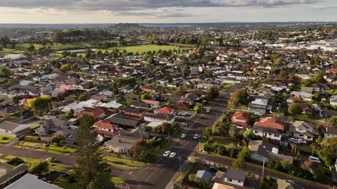 Car turns onto quiet tree lined residential street in Mount Roskill suburb Stock Footage 345851387