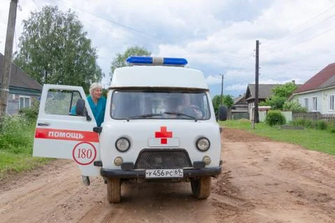 Car UAZ SGR ("Loaf") AMBULANCE arrived on call, the doctor gets in the car. Stock Photos