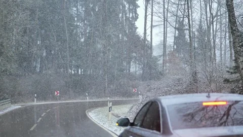 Car under the snow. Snowfall on the road. snowy weather. Stock Footage 250102349