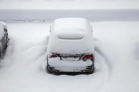 Car under a thick layer of snow. Snow-covered cars during a winter blizzard Stock Photos