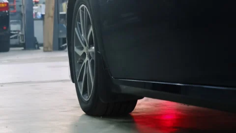 Car with underglow drives through hall of service center Stock Footage 317629632