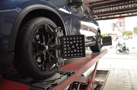 The car is undergoing wheel alignment maintenance Stock Photos