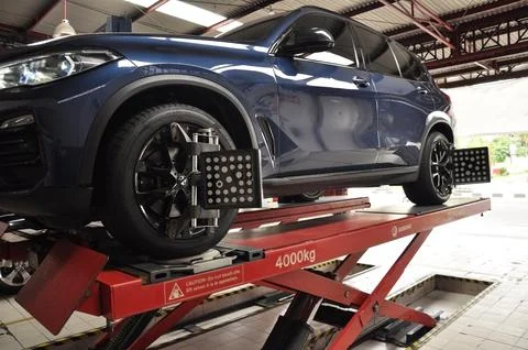 The car is undergoing wheel alignment maintenance Stock Photos