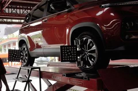 The car is undergoing wheel alignment maintenance spooring and balancing Stock Photos