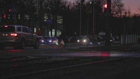 Car waiting on red stop light while pedestrians go through the zebra Stock Footage 169980042