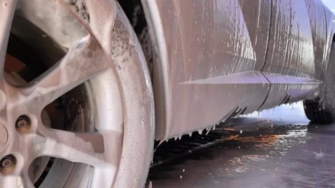 Car wash. Cleaning the car using high pressure water spraying. White soap foam. Stock Footage 245551730