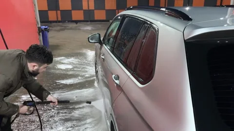 Car wash. Cleaning the car using high pressure water spraying. White soap foam. Stock Footage 271346359