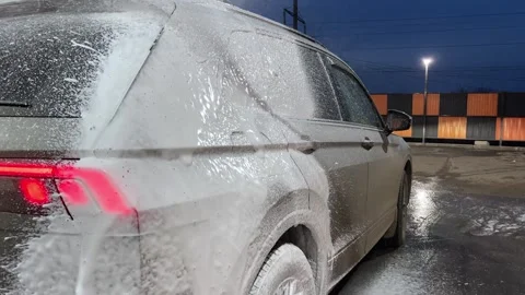Car wash. Cleaning the car using high pressure water spraying. White soap foam. Stock Footage 271346458