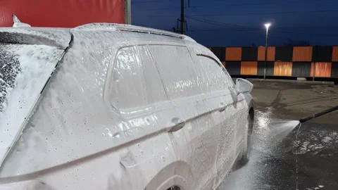 Car wash. Cleaning the car using high pressure water spraying. White soap foam. Stock Footage 272435163