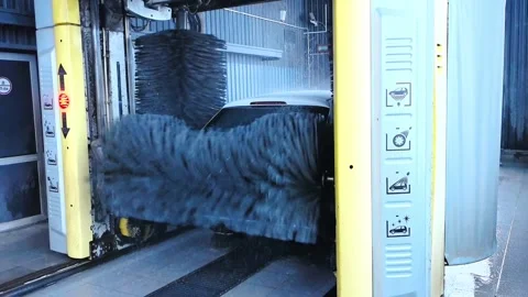 Car wash at a local facility with automatic brushes and water spray on a weekday Stock-Footage 328488708