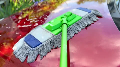 Car wash mop cleaning red car hood Stock Footage 310095120