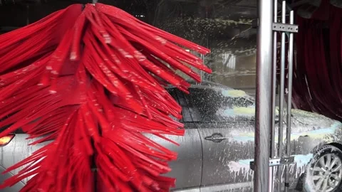 Car wash in slow motion. Rotating brushes and foam being sprayed. Stock Footage 261586426