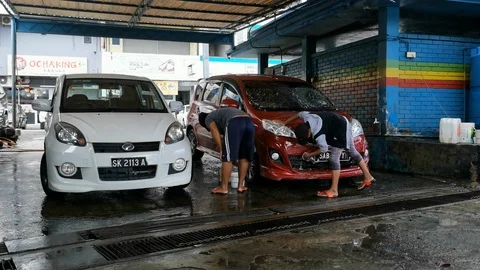 Car wash worker are working hard to wash a dirty car. Video stock 124177688