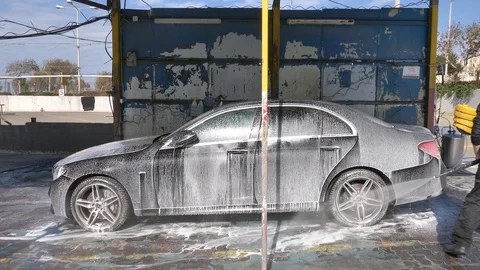 Car wash worker using Jet Pressure Washer to clean a Black Mercedes. Stock Footage 123064718