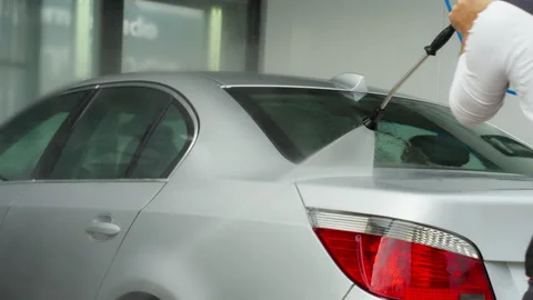 Car washer clea modern silver vehicle at self-service station. Worker use h.. Stock Footage 320890632