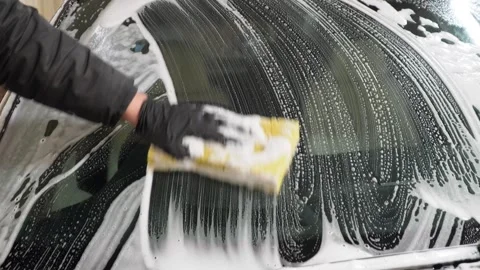 Car washer does full body car wash with soap and yellow sponge. Stock Footage 331529392