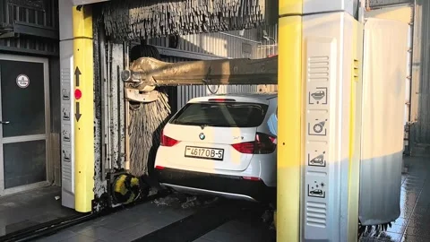 Car washing at a facility with automatic equipment in the afternoon Stock Footage 327102077
