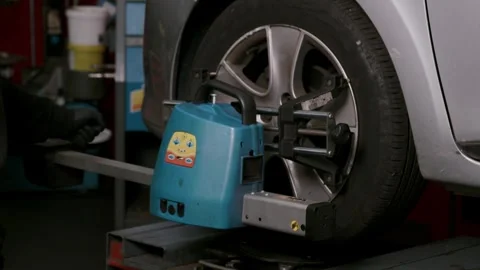 Car wheel alignment machine measuring tire angle in auto workshop Stock Footage 332042702