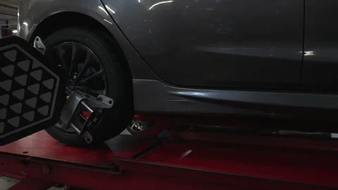 Car wheel with alignment sensor equipment in a mechanical workshop Stock Footage 331070013