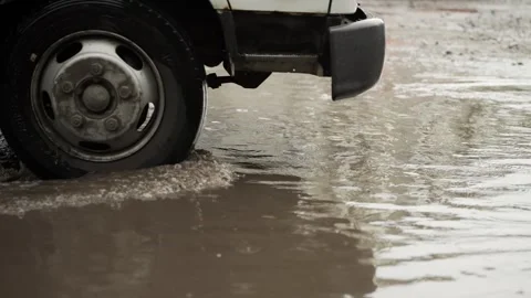 Car Wheel Driving Through Flooded Rainy Street Close Up 스톡 동영상 340482939