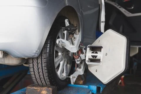 Car wheel fixed with computerized wheel alignment machine clamp Stock Photos