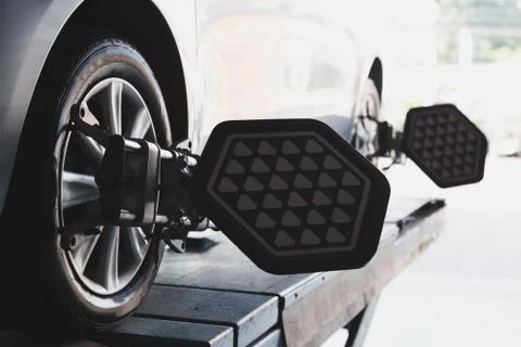Car wheel fixed with computerized wheel alignment machine clamp Stock Photos