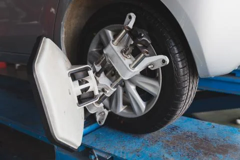 Car wheel fixed with computerized wheel alignment machine clamp Stock Photos