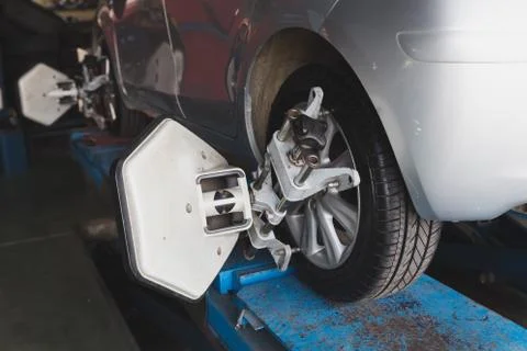 Car wheel fixed with computerized wheel alignment machine clamp Stock Photos