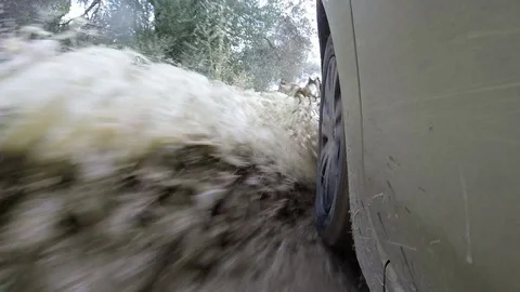 Car wheel passes through dirty waters on a rural road 스톡 동영상 126930699
