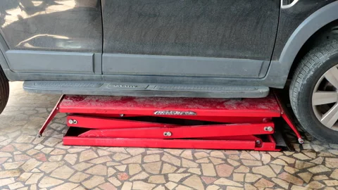 The car, whose repair is completed at the service station, is taken off the lift Stock-Footage 256242544