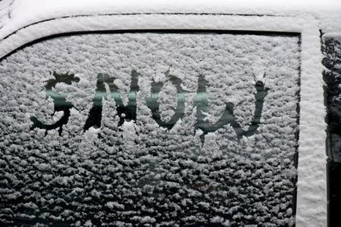 A car window covered with dusting of snow with the word snow written in it Stock Photos