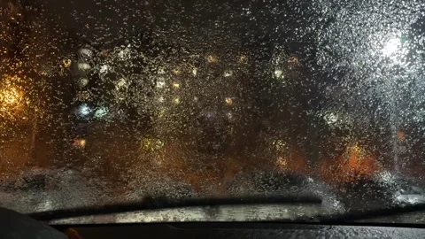 A car window is covered in rain and the street lights are on Stock-Footage 274261155