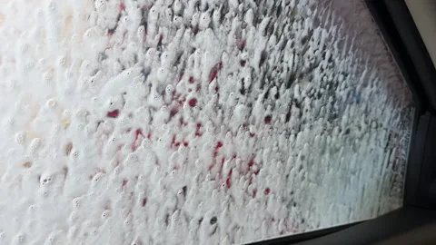 Car window during wash, soap bubbles, red arrow, reflections, water streaks 動画素材 330991527