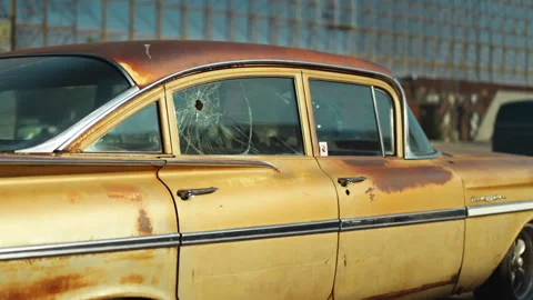 Car window shattered by multiple bullet holes on a city Stock Footage 330954075