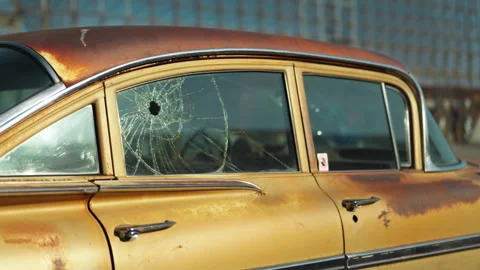 Car window shattered by multiple bullet holes on a city Stock Footage 330954331