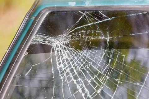 A car window is shattered with a spider web pattern Foto stock