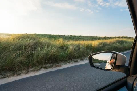 Car window view with grassy dunes and road on Sylt island Stock Photos