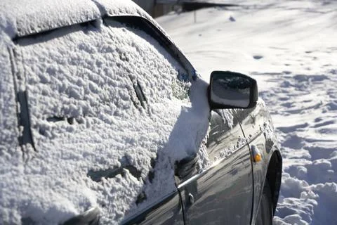Car Windows are covered with a layer of snow. Close - up of the car after a s Stock Photos