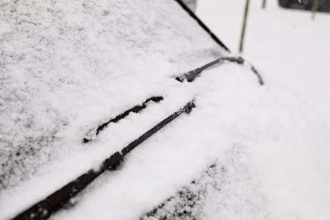 Car windshield covered in deep snow with raised wiper blade Stock Photos