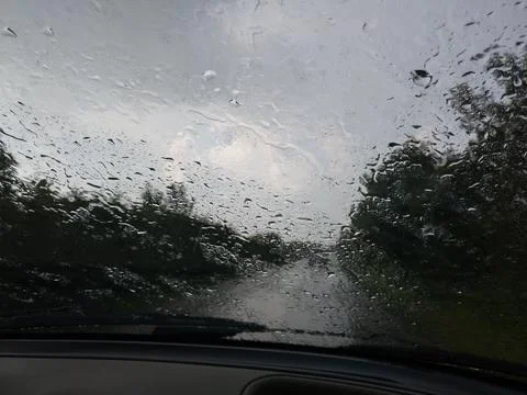 Car windshield covered with rain drops while driving, low visibility Stock Photos