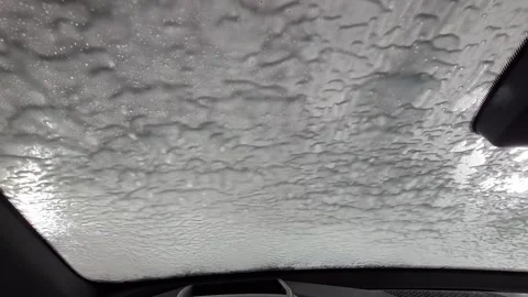 A car windshield is covered in a white substance Stock Footage 303294321