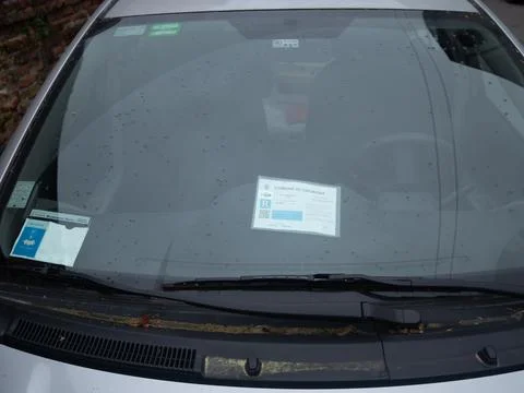 Car windshield with parking permit and rain drops, close-up view Stock Photos