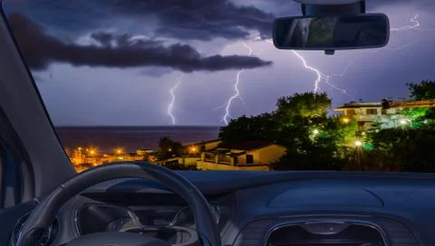 Car windshield with view of lightning storm over the sea Stock Photos