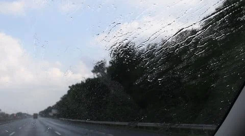 Car windshield view of rainfall splashing and dripping Stock Photos