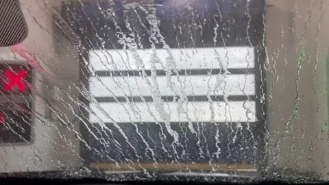 Car windshield view of water dripping and wiping off during car wash Stock Footage 340527342