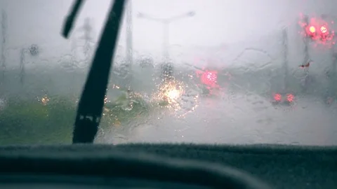 Car windshield wiper are removing rain while driving on the road in the bad weat Stock Footage