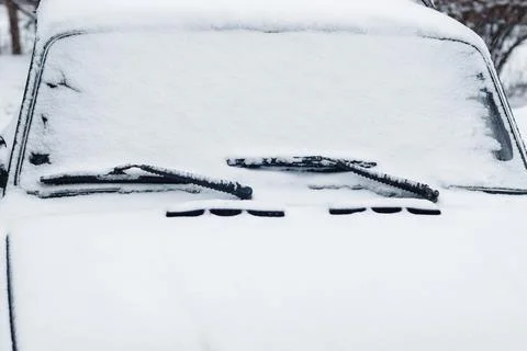 Car windshield wipers and windscreen in snow, closeup Stock Photos