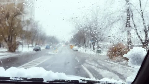 Car windshield wipers clear snow, ice, water drops from the windshield Stock Footage 297969105