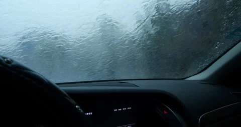 Car windshield wipers clearing heavy rain during a storm on a gloomy day Stock Footage 342279051